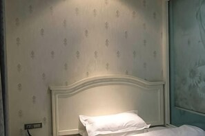 A room with a bed, a wall socket, and a patterned wallpaper. - Cangnan Water View Hotel (Cangnan)