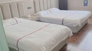 A hotel room with two beds, a nightstand, and a window with curtains. - Cangnan Water View Hotel (Cangnan)