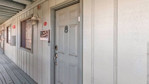 Une rangée de portes en bois peintes en blanc, avec une enseigne au-dessus de chaque porte.