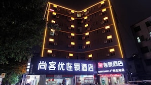 A hotel with multiple floors, illuminated by warm interior lighting. - Shankee Chain Hotel (Guangzhou North Station Huacheng Road Subway Station) (Guangzhou)