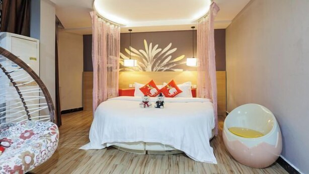 A hotel room with a bed, a round seating area, and a unique ceiling light fixture. - Shankee Chain Hotel (Guangzhou North Station Huacheng Road Subway Station) (Guangzhou)