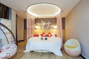A hotel room with a bed, a round seating area, and a unique ceiling light fixture. - Shankee Chain Hotel (Guangzhou North Station Huacheng Road Subway Station) (Guangzhou)
