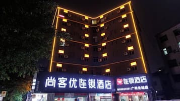 A multi-story hotel with illuminated signage and a visible entrance.