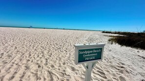 A beach sign indicating 'Sandpiper Beach Condominium PRIVATE'.