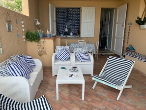 Relax in this inviting outdoor space with a wicker sofa, armchair, and dining table.