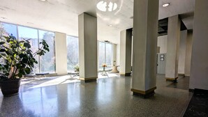 A spacious lobby with large windows, a potted plant, and a reception desk. - Downtown/Midtown "Family ATL CityScape" (Atlanta)