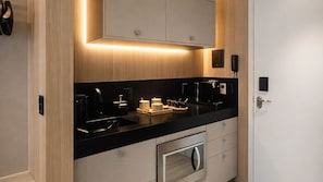 A modern kitchen with a black countertop, stainless steel appliances, and wooden cabinetry. - AX Setai Yacht (João Pessoa)