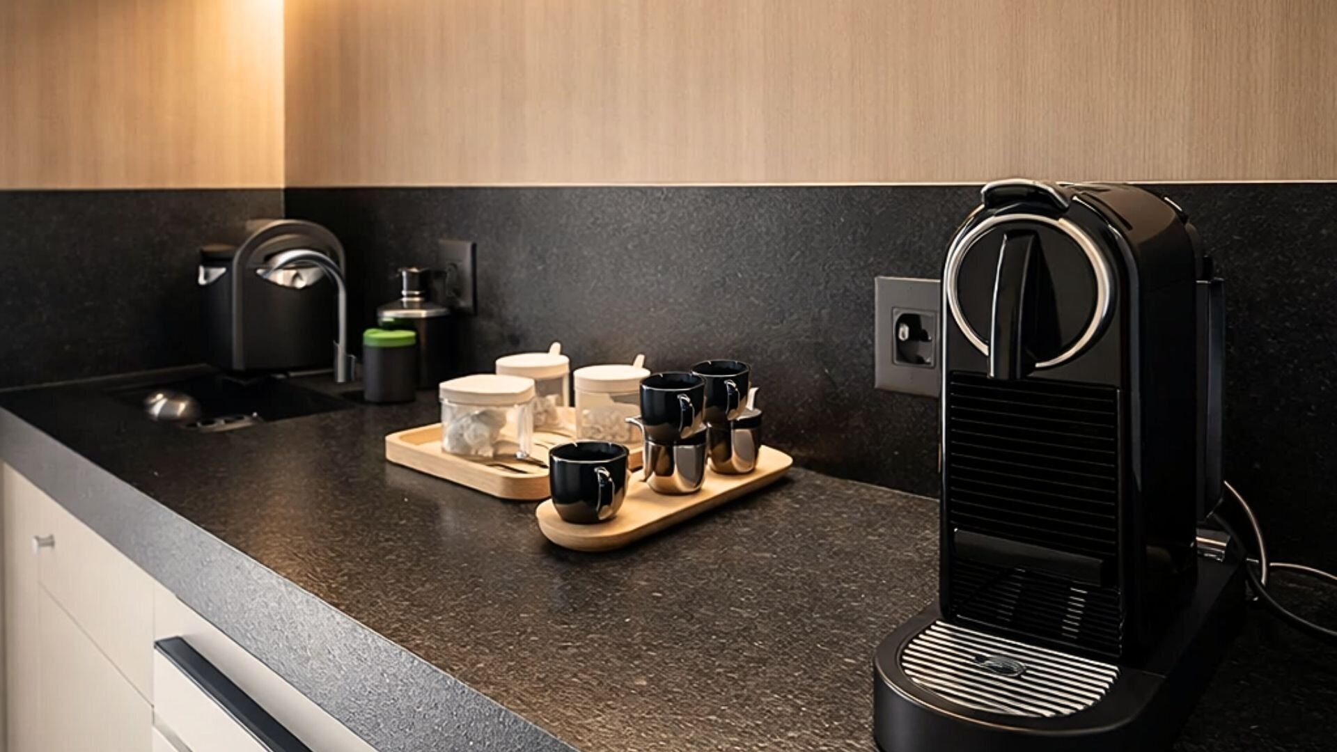 Eine moderne Küche mit einer Kaffeemaschine, einer Tablett mit Tassen und einem Wasserkocher.