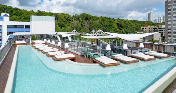 A cruise ship deck with a pool, sun loungers, and umbrellas. - AX Setai Yacht (João Pessoa)