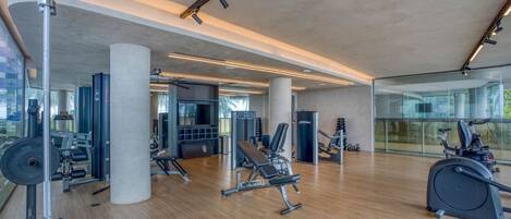Un gimnasio moderno con equipo de ejercicio, ventanas amplias y un diseño espacioso.