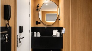 A modern bathroom with a black sink, a mirror, a towel rack, and a telephone. - AX Setai Yacht (João Pessoa)