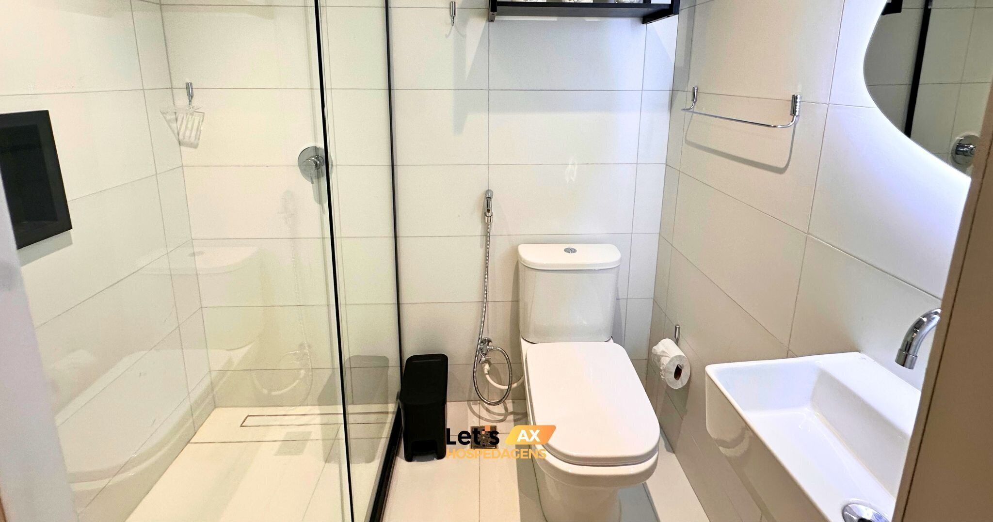 Et moderne badeværelse med brusekabine i glas, toilet og badekar.