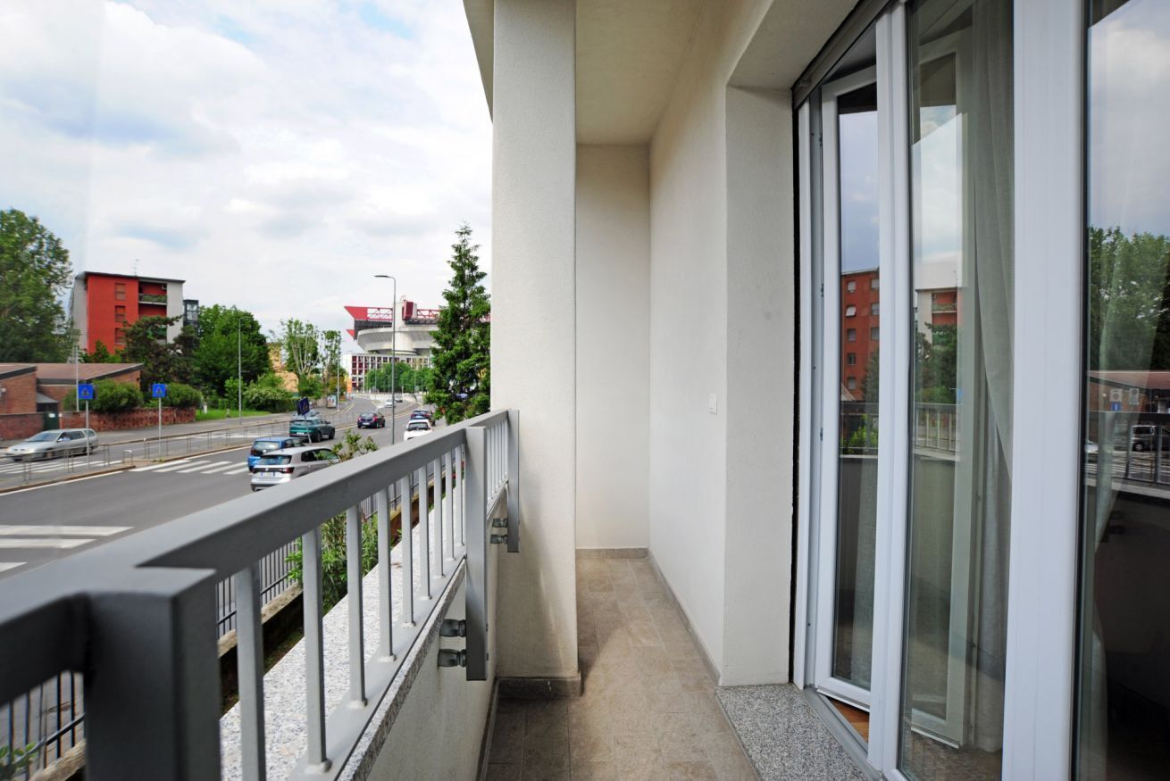 Un balcone con vista su una strada e degli edifici.
