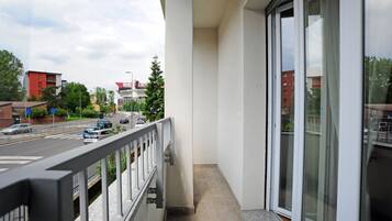 Un balcone con vista su una strada e degli edifici.