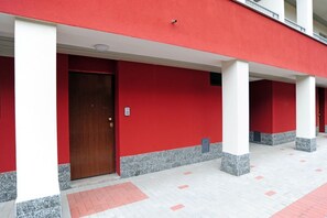 A building with red walls, white columns, and a wooden door. - San Giusto Apartment (Milano)