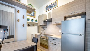 Une cuisine moderne avec des meubles en bois, un réfrigérateur en acier inoxydable et un four encastré.