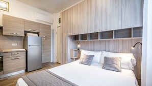 Une chambre à coucher moderne avec un lit, des tables de chevet et une armoire intégrée.