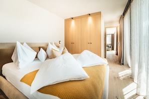 Une chambre d’hôtel avec un lit, une armoire et une vue sur le couloir.