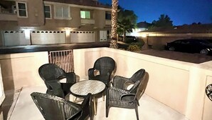 An outdoor patio with wicker furniture and a palm tree. - Condominium close to New Raider’s stadium, Strip, restaurants and attractions.  (Las Vegas)