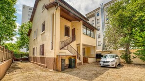 A two-story building with a staircase leading to the upper floor, a car parked in front, and a trash bin near the entrance. - Le Petit Gerland - Agréable à 1 minute du métro B (Lyon)