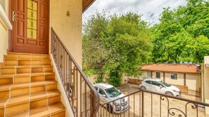 A residential property with a staircase leading to a door, a fenced yard with two cars, and a building with a tiled roof. - Le Petit Gerland - Agréable à 1 minute du métro B (Lyon)