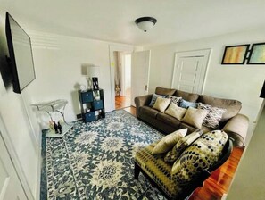 Cozy living space with a sofa, side table, and shelving unit.