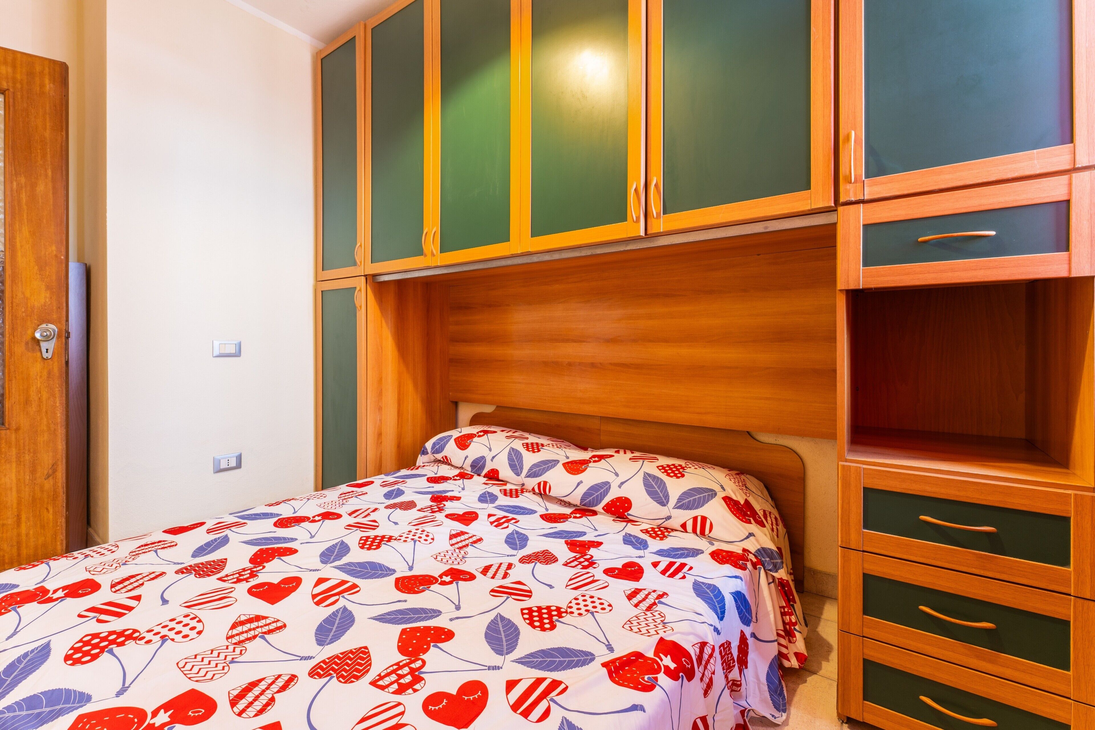 Ein Schlafzimmer mit einem Bett, einem Holzschrank und einem Nachttisch.