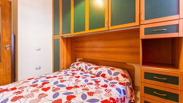 Ein Schlafzimmer mit einem Bett, einem Holzschrank und einem Nachttisch.