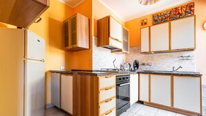 A kitchen with a refrigerator, oven, and cabinets. - Holiday Home 'Magy House' with Private Terrace (Quartu Sant'elena)