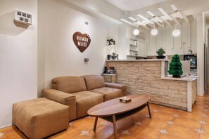 A living room with a sofa, ottoman, and a wooden coffee table. - Xinhaiminsu (Hualien)