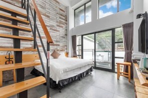 A bedroom with a bed, a wooden bench, a desk, and a large window. - Xinhaiminsu (Hualien)