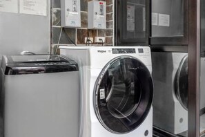 A front-loading washing machine with a digital display, a dryer, and a refrigerator in a laundry room. - Xinhaiminsu (Hualien)