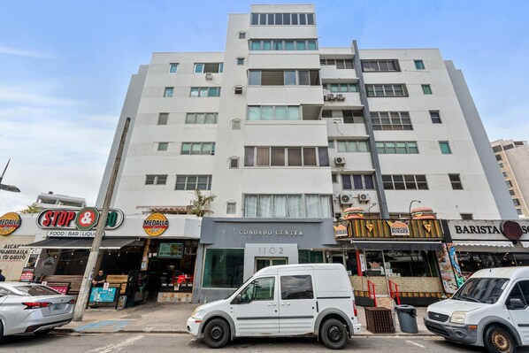 A multi-story building with various commercial establishments on the ground floor, including a restaurant and a bar.