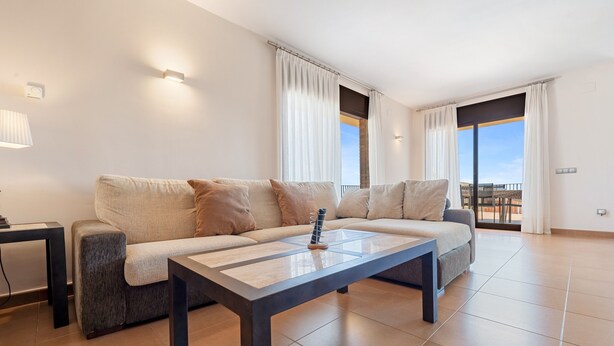 A modern living room with a sofa, a coffee table, and a view through large windows. - Holiday Home 'Casa Tico' with Private Pool, Wi-Fi (Roda De Bara)