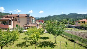 A residential area with houses, a clear sky, and a hilly landscape in the background. - Apartment 'Da Dri´' with Private Terrace, Private Garden and Balcony (Brugnato)