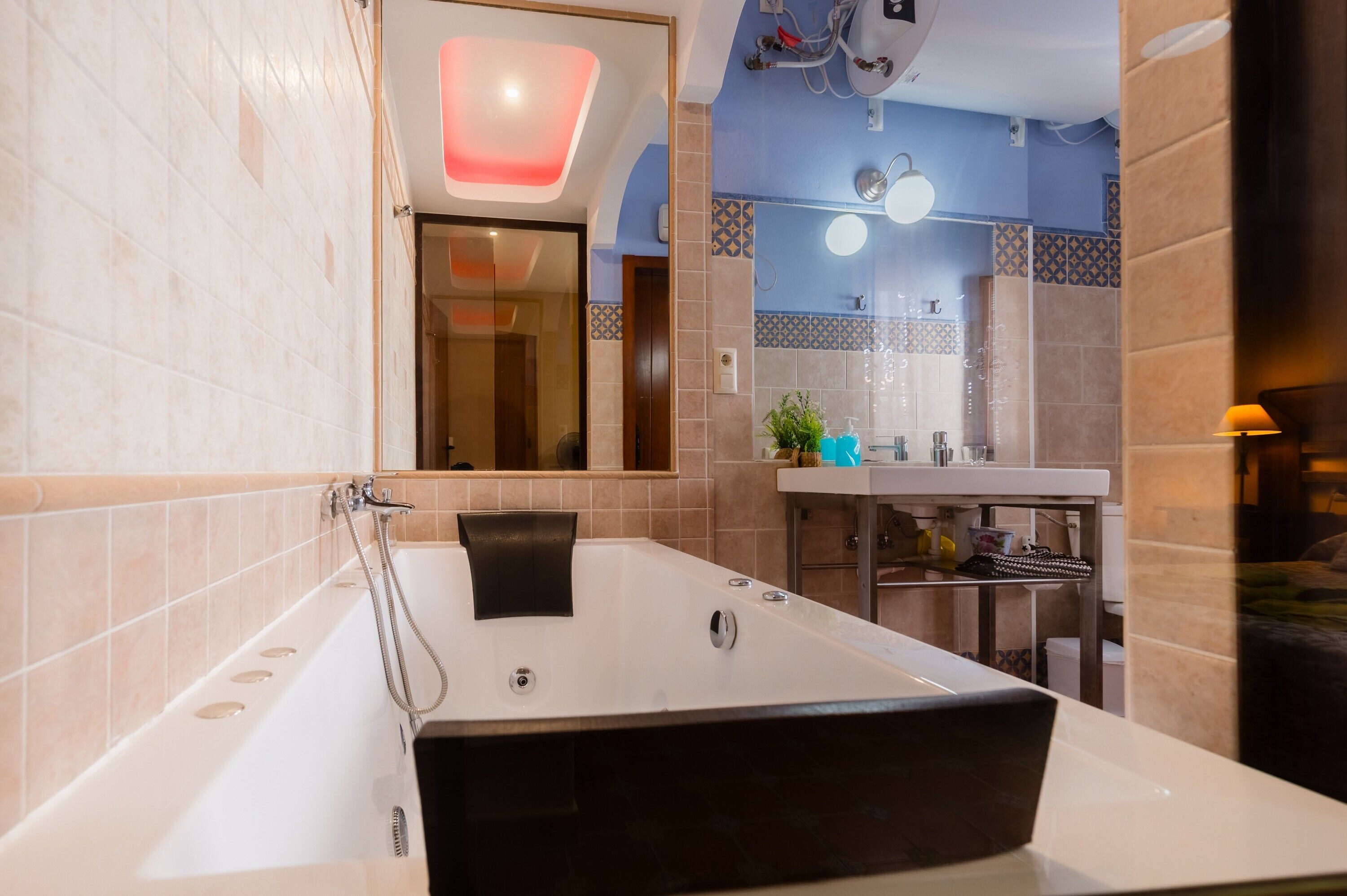 Un baño moderno con una bañera grande, un lavabo y un espejo.