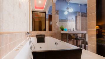 Un baño moderno con una bañera grande, un lavabo y un espejo.