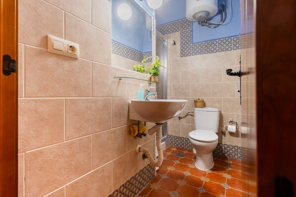 A bathroom with a sink, toilet, and shower.