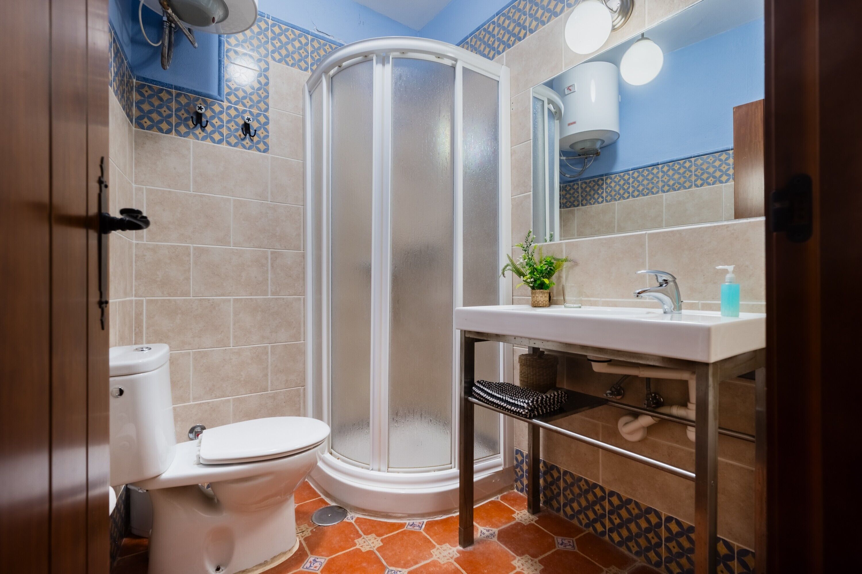 Une salle de bain équipée de toilettes, d’une douche, d’un lavabo et d’un miroir.