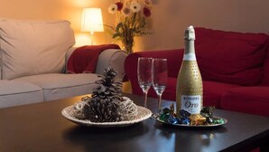 Una bottiglia di RONDEL Oro su un tavolo con una pigna decorativa e due bicchieri.