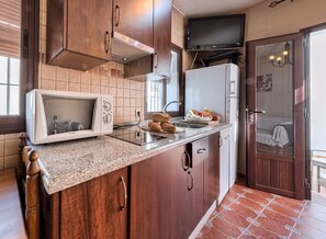 Una cocina compacta equipada con microondas, tostadora y refrigerador.
