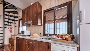 A kitchen with wooden cabinets, a microwave, a sink, and a dishwasher.