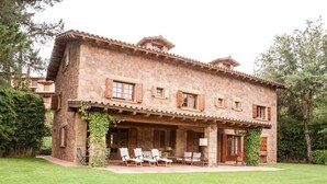 A stone building with a covered patio and outdoor seating. - Country Home 'Gran Castanyer' with Mountain View, Private Pool and Wi-Fi (Viladrau)