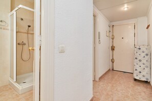Een badkamer met een douche, toilet en wastafel.