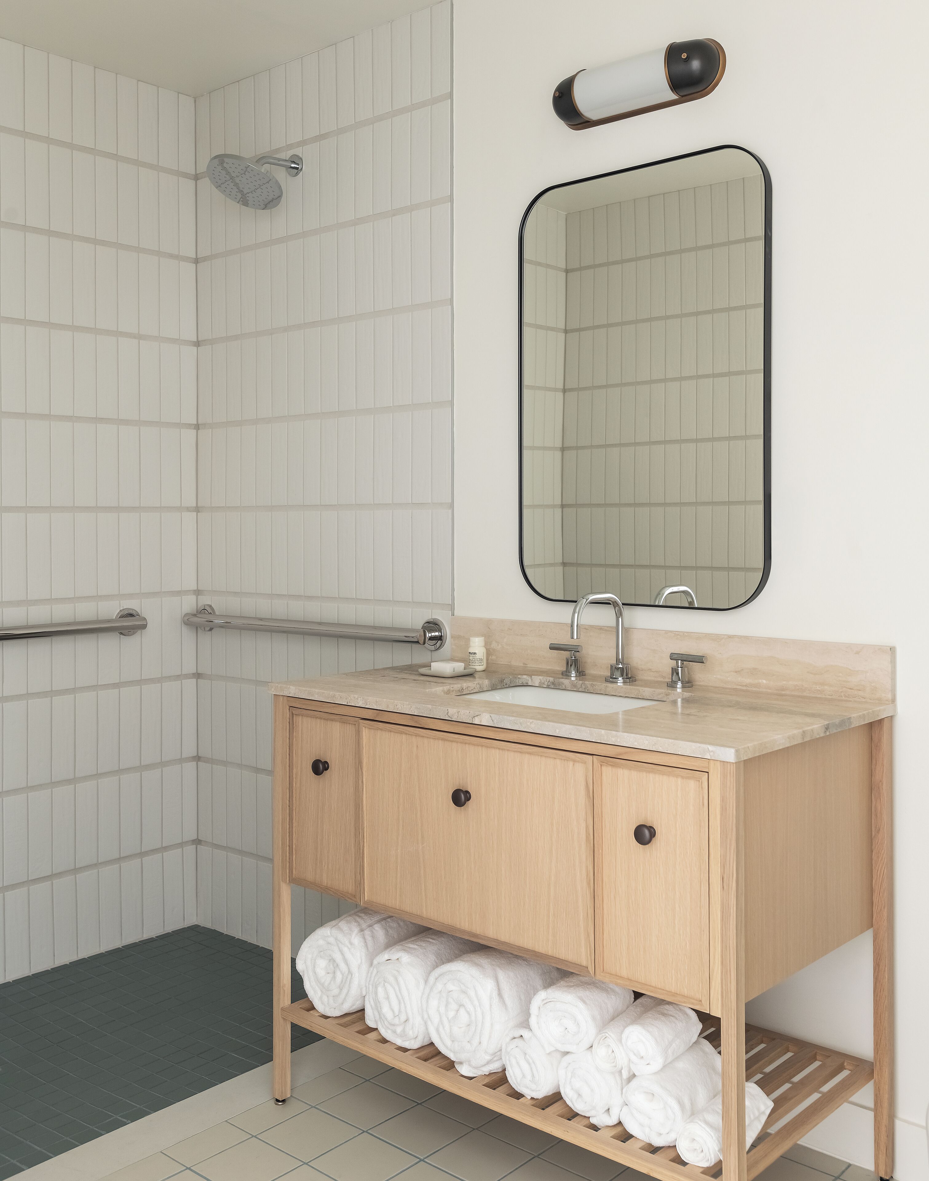 A modern bathroom with a shower, a sink with a mirror, and a towel rack.