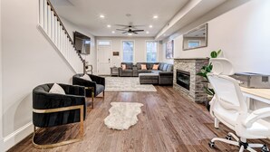 A modern living room with a staircase, a fireplace, and a desk area. - Contemporary, Cozy, & Convenient in Old Town Alexandria (Alexandria)