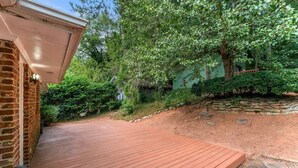 A wooden deck with a brick wall and a stone wall in the background.