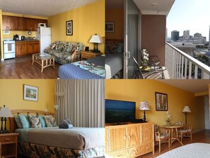 Een hotelkamer met een keuken, een balkon met uitzicht op de stad, een bed met bloemenprint beddengoed, een televisie en een eethoek met een tafel en stoelen.