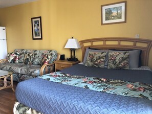 A hotel room with a bed, a sofa, a nightstand, a lamp, and two framed pictures on the wall. - 💎LOCATION💎 5min to 🏄‍♀️🏊‍♀️🐠🦈🌸 free parking 🚙🅿️, fast WIFI💻 🌺F15A06🌺 (Honolulu)