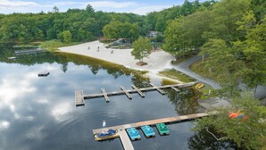 Un muelle a orillas del lago con barcos y un parque infantil.